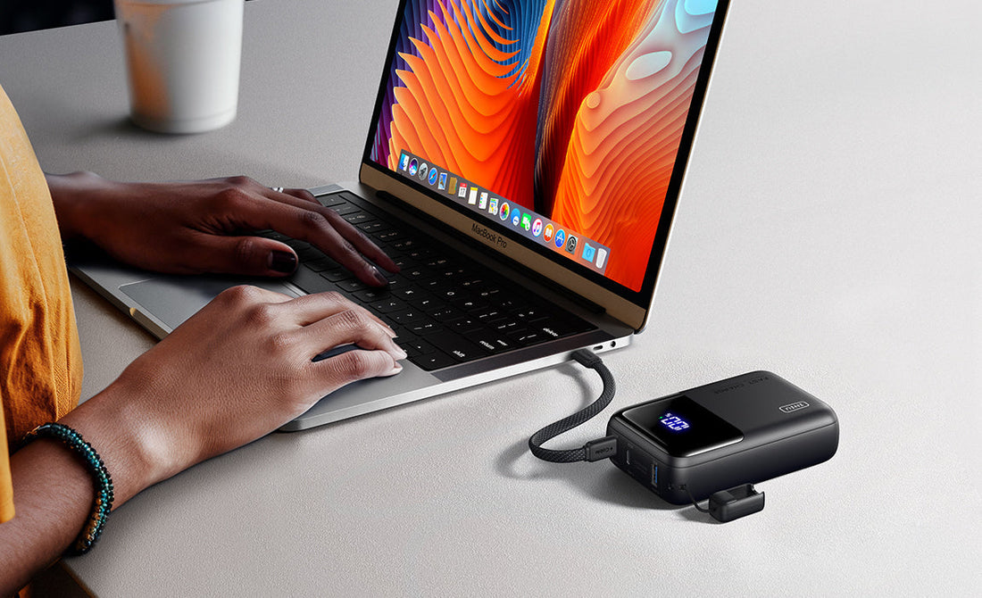 Portable laptop charger connected to a laptop on a desk